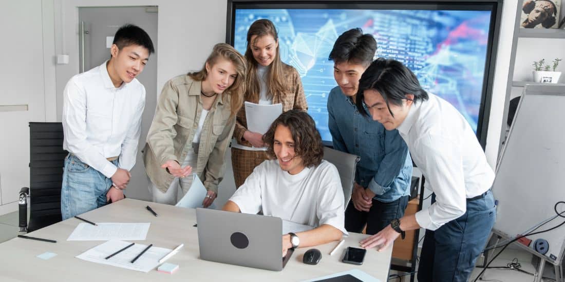 Satisfied team viewing laptop